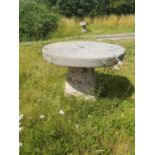 Garden Tables/Furniture: A carved stone table with millstone top on staddlestone base, 80cm high
