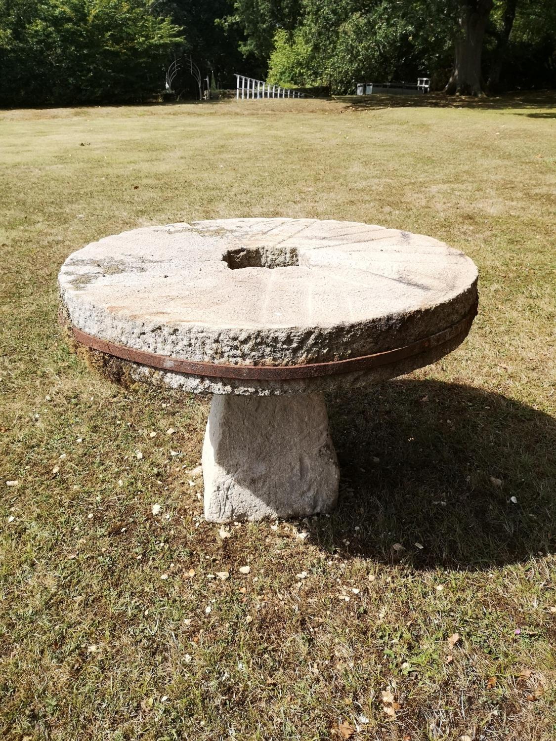 Garden Tables/Furniture: A carved stone table with millstone top on staddlestone base, 107cm