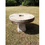 Garden Tables/Furniture: A carved stone table with millstone top on staddlestone base, 107cm