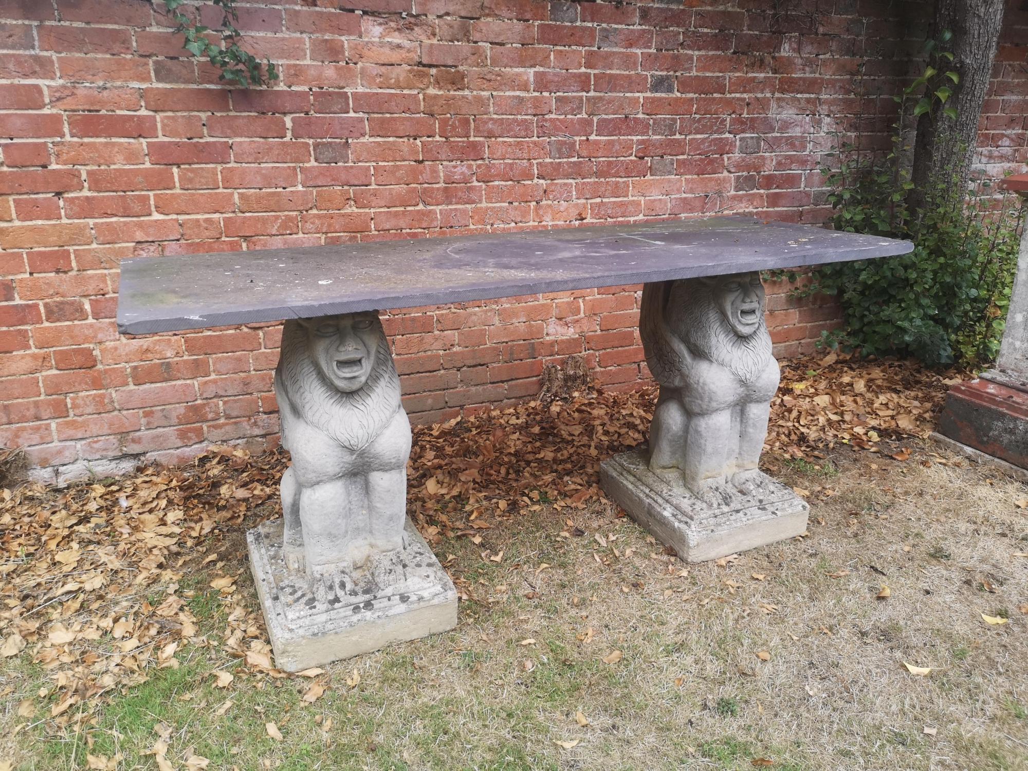 Garden tables/furniture: A slate table on grotesque animal composition stone supports, 183cm long