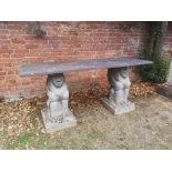 Garden tables/furniture: A slate table on grotesque animal composition stone supports, 183cm long