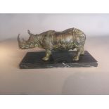 Sculpture: A bronze rhinoceros modern on marble base 19cm high by 38cm long