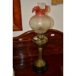 Ruby glass tipped and brass column oil lamp