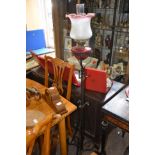 Cranberry glass duplex brass oil lamp on cast iron stand