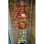 Ruby glass and brass column oil lamp