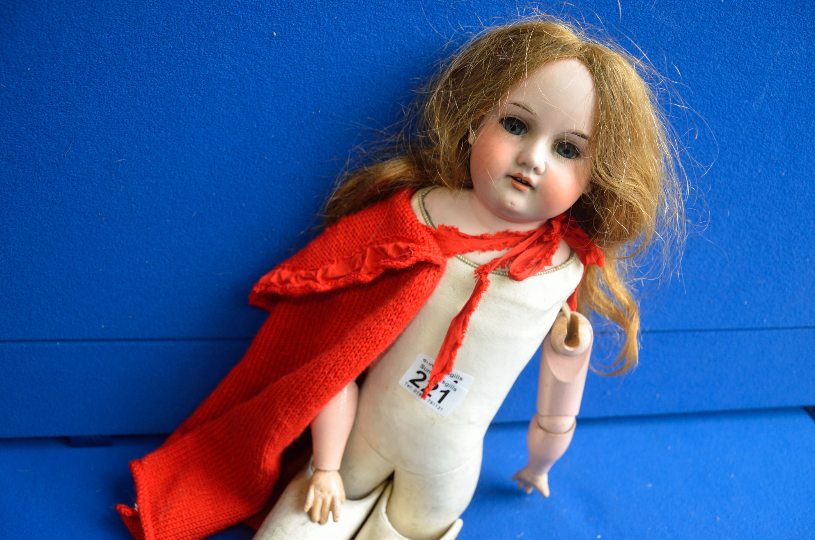 Bisque doll with red cape