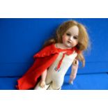 Bisque doll with red cape