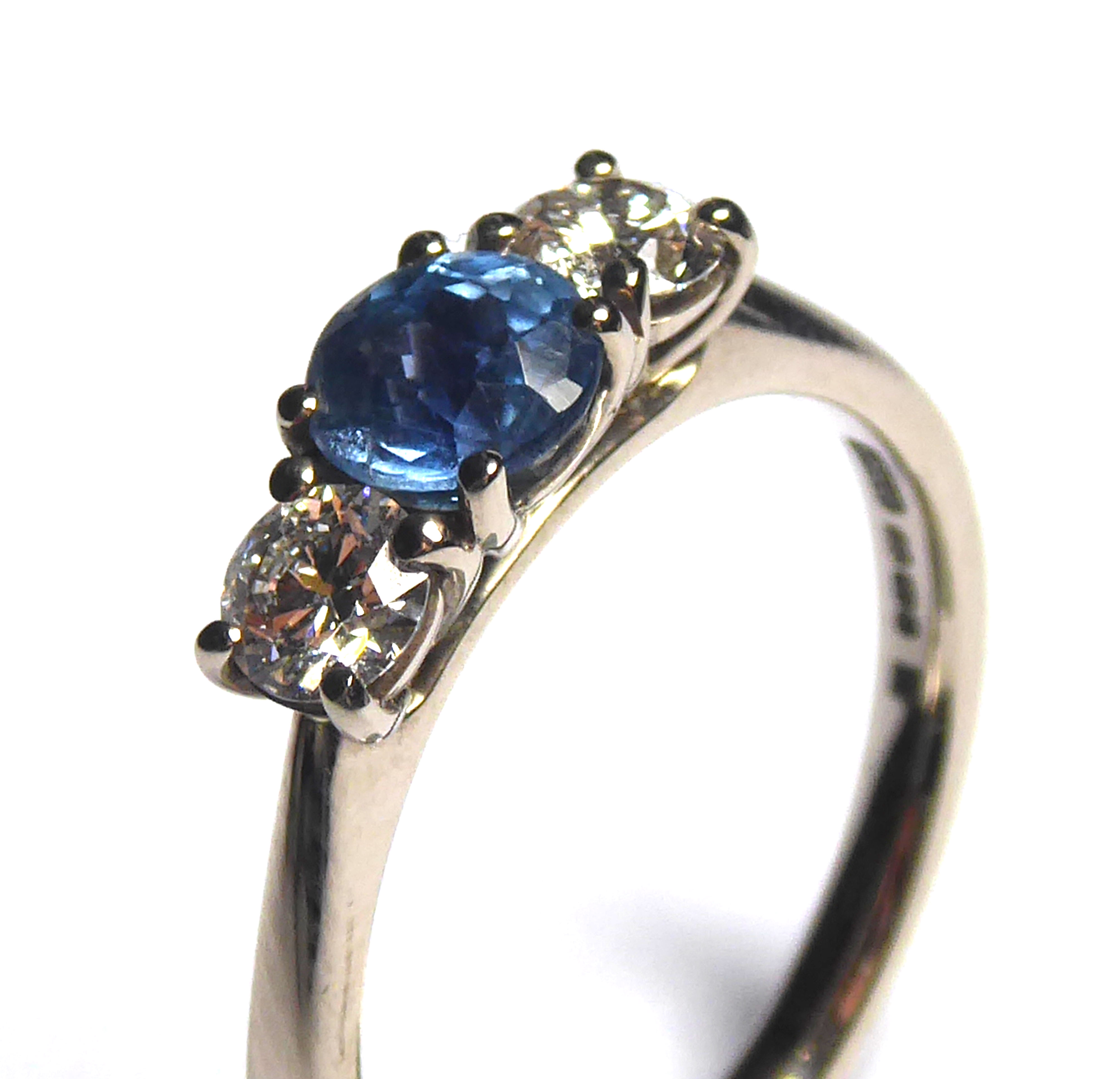 AN 18CT WHITE GOLD, SAPPHIRE AND DIAMOND THREE STONE RING Having a round cut sapphire flanked with