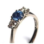 AN 18CT WHITE GOLD, SAPPHIRE AND DIAMOND THREE STONE RING Having a round cut sapphire flanked with