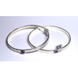 TWO WHITE METAL BANGLES Set with amethyst.