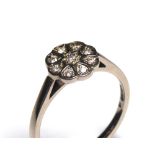 AN 18CT WHITE GOLD AND DIAMOND DAISY CLUSTER RING Having an arrangement of round cut diamonds (