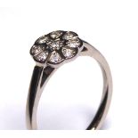 AN 18CT GOLD AND DIAMOND DAISY CLUSTER RING Having an arrangement of round cut diamonds (size K).
