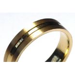 AN 18CT GOLD GENT'S WEDDING BAND Having an engraved tramline design on planished ground (size P).