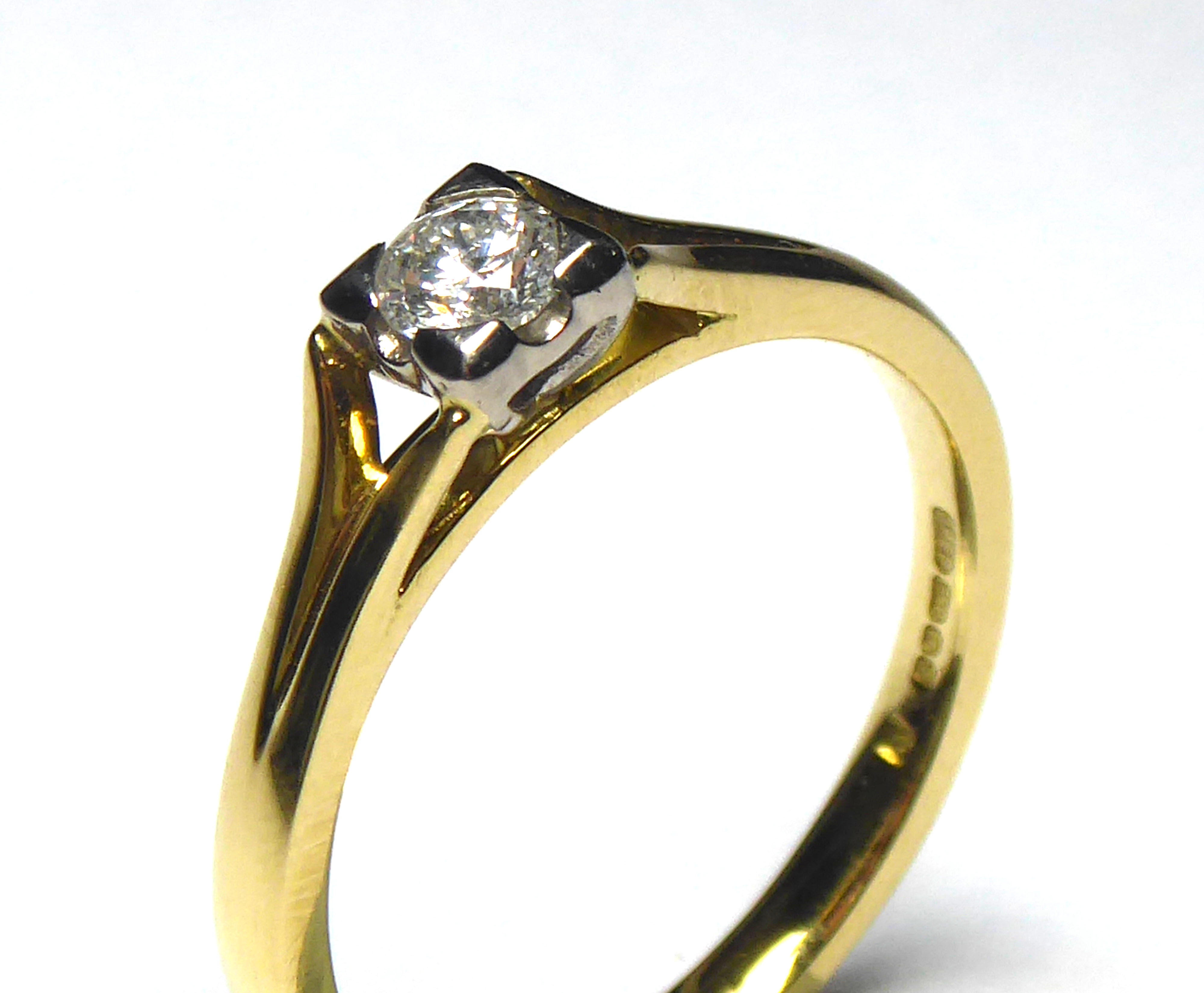 AN 18CT GOLD AND DIAMOND SOLITAIRE RING The single round cut diamond in a raised mount (size M). (