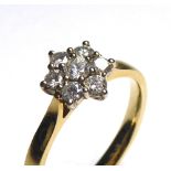 AN 18CT GOLD AND DIAMOND DAISY CLUSTER RING Having an arrangement of round cut diamonds. (approx