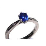 AN 18CT WHITE GOLD, SAPPHIRE AND DIAMOND RING Having an oval cut sapphire with diamond set to