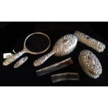 AN EARLY 20TH CENTURY SILVER DRESSING TABLE SET Comprising a hand mirror, three brushes and a