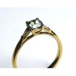 AN 18CT GOLD, SAPPHIRE AND DIAMOND RING Having a Princess cut teal sapphire with baguette cut