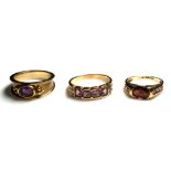 A COLLECTION OF THREE 9CT GOLD AND GEM SET DRESS RINGS Two set with garnets and one with amethyst (