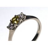 AN 18CT WHITE GOLD, YELLOW SAPPHIRE AND DIAMOND THREE STONE RING Having a round cut sapphire flanked
