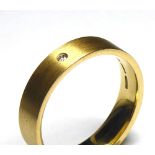 AN 18CT GOLD WEDDING BAND Planished finish and set with a single diamond (size Q/R).