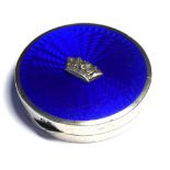 AN EARLY 20TH CENTURY SILVER AND BLUE ENAMEL PILL BOX Circular form, with embossed coronet on blue