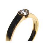 AN 18CT GOLD AND DIAMOND SOLITAIRE RING The single round cut diamond in a rubover mount (size K/