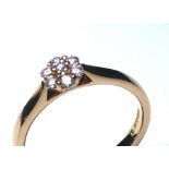 AN 18CT GOLD AND DIAMOND DAISY CLUSTER RING Having an arrangement of round cut diamonds (size M).