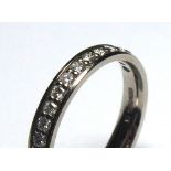 AN 18CT WHITE GOLD HALF ETERNITY RING Having a row of round cut diamonds (size L).