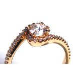 AN 18CT ROSE GOLD AND ROUND BRILLIANT CUT DIAMOND CROSSOVER RING Flanked by diamond encrusted