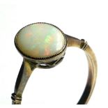 A VINTAGE YELLOW METAL AND OPAL RING Having a single cabochon cut opal in a plain gold mount (size