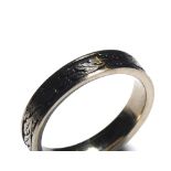 AN 18CT WHITE GOLD AND ENAMEL WEDDING BAND Having an engraved laurel leaf design on black enamel