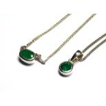 TWO EMERALD PENDANTS On white metal chains.