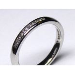 AN 18CT WHITE GOLD HALF ETERNITY RING Having a single row of diamonds (size K/L).