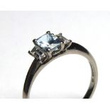 AN 18CT GOLD, AQUAMARINE AND DIAMOND THREE STONE RING Having an emerald cut stone flanked by