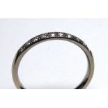AN 18CT WHITE GOLD AND DIAMOND HALF ETERNITY RING Having a row of round cut diamonds (size M).