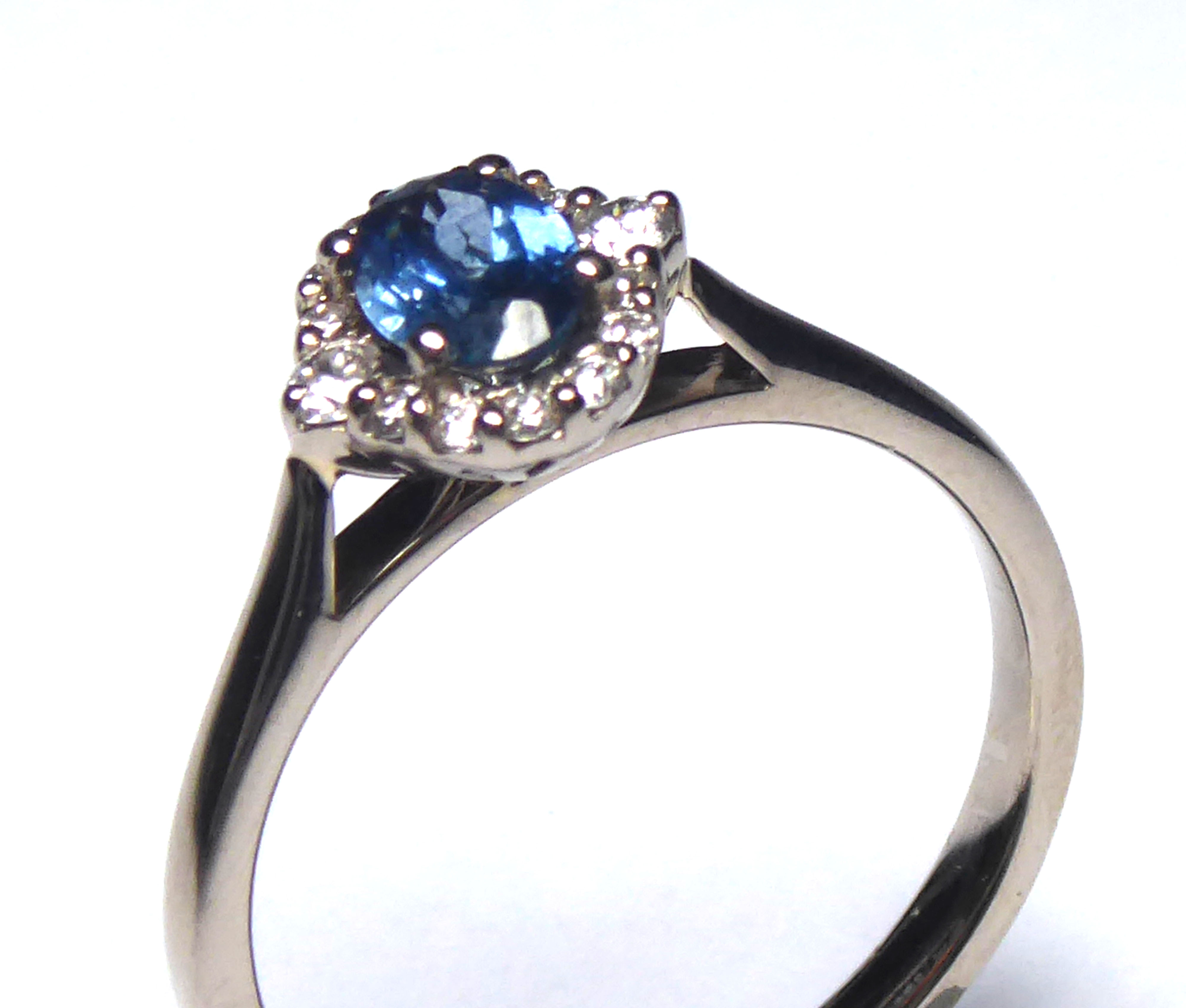 AN 18CT GOLD, WHITE SAPPHIRE AND DIAMOND RING Having an oval cut sapphire edged with diamonds (