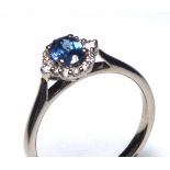AN 18CT GOLD, WHITE SAPPHIRE AND DIAMOND RING Having an oval cut sapphire edged with diamonds (