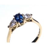 AN 18CT GOLD, SAPPHIRE AND DIAMOND THREE STONE RING Having an oval cut sapphire flanked by pear