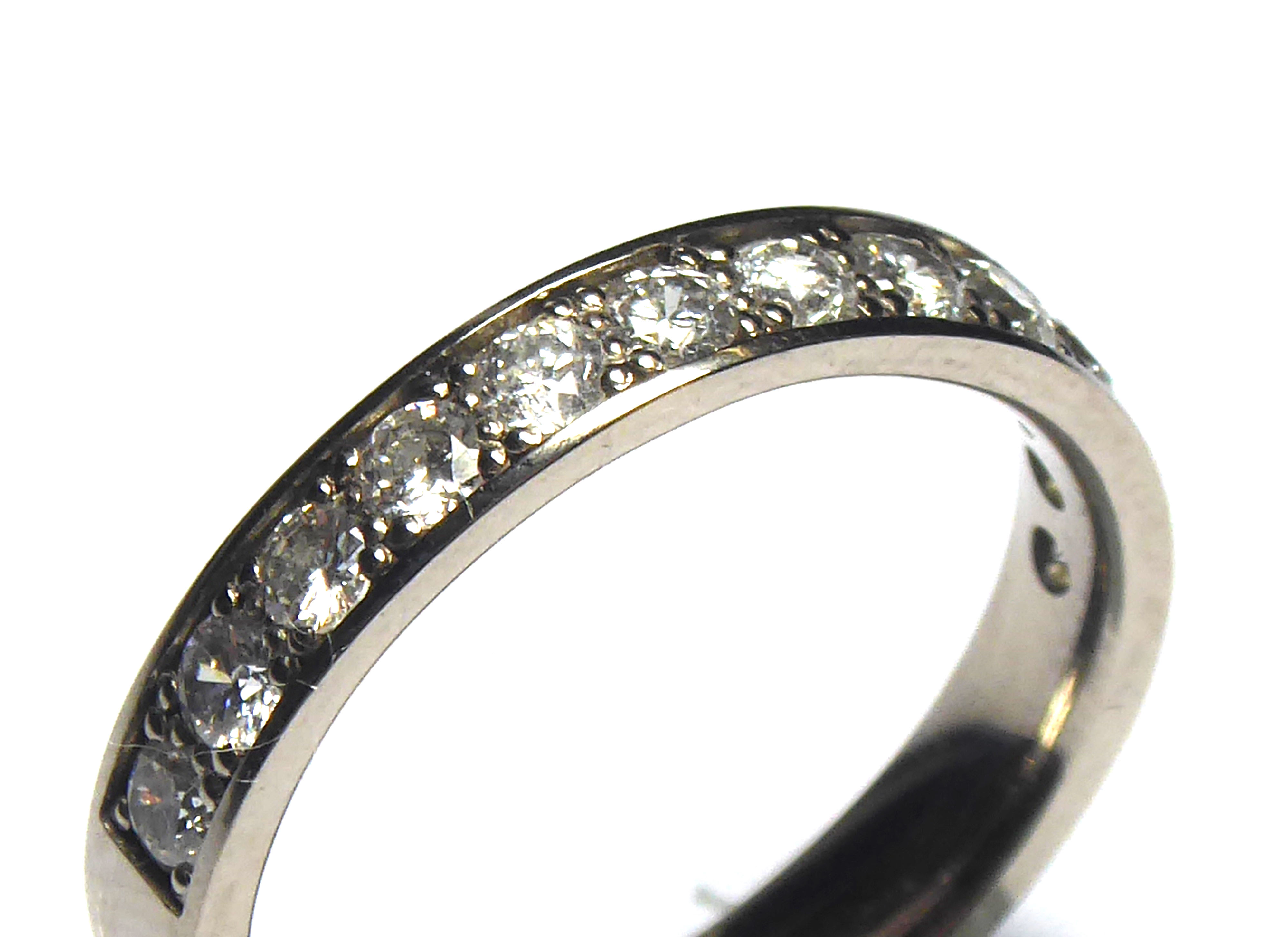 AN 18CT WHITE GOLD AND DIAMOND HALF ETERNITY RING Having a single row of round cut diamonds (size