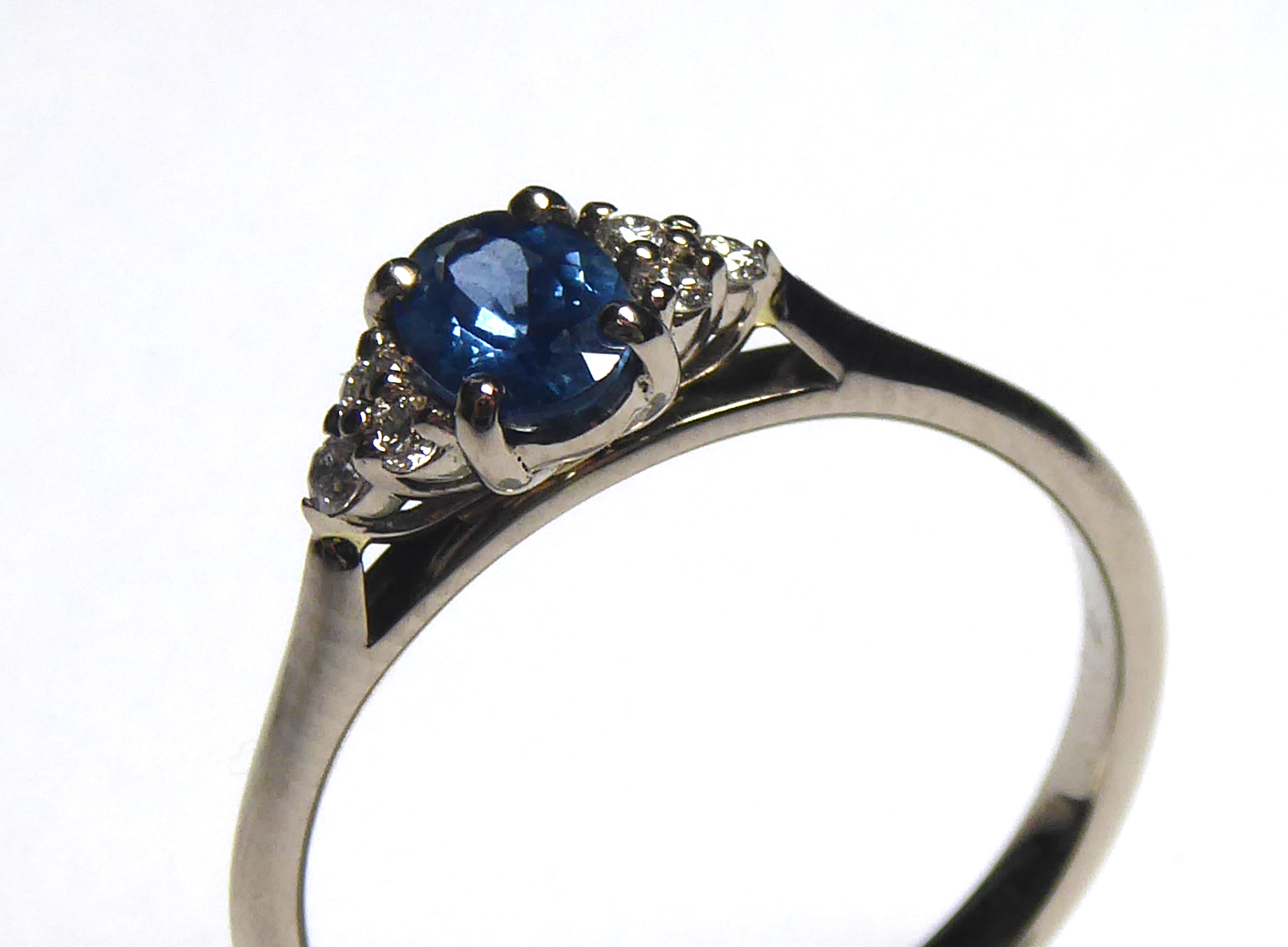 AN 18CT GOLD, SAPPHIRE AND DIAMOND RING Having a single oval cut sapphire flanked by diamonds (