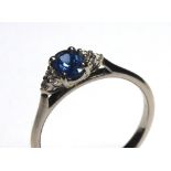 AN 18CT GOLD, SAPPHIRE AND DIAMOND RING Having a single oval cut sapphire flanked by diamonds (