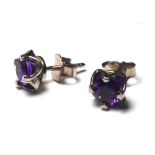 A PAIR OF 18CT WHITE GOLD AND AMETHYST STUD EARRINGS Each set with a single round stone in a pierced