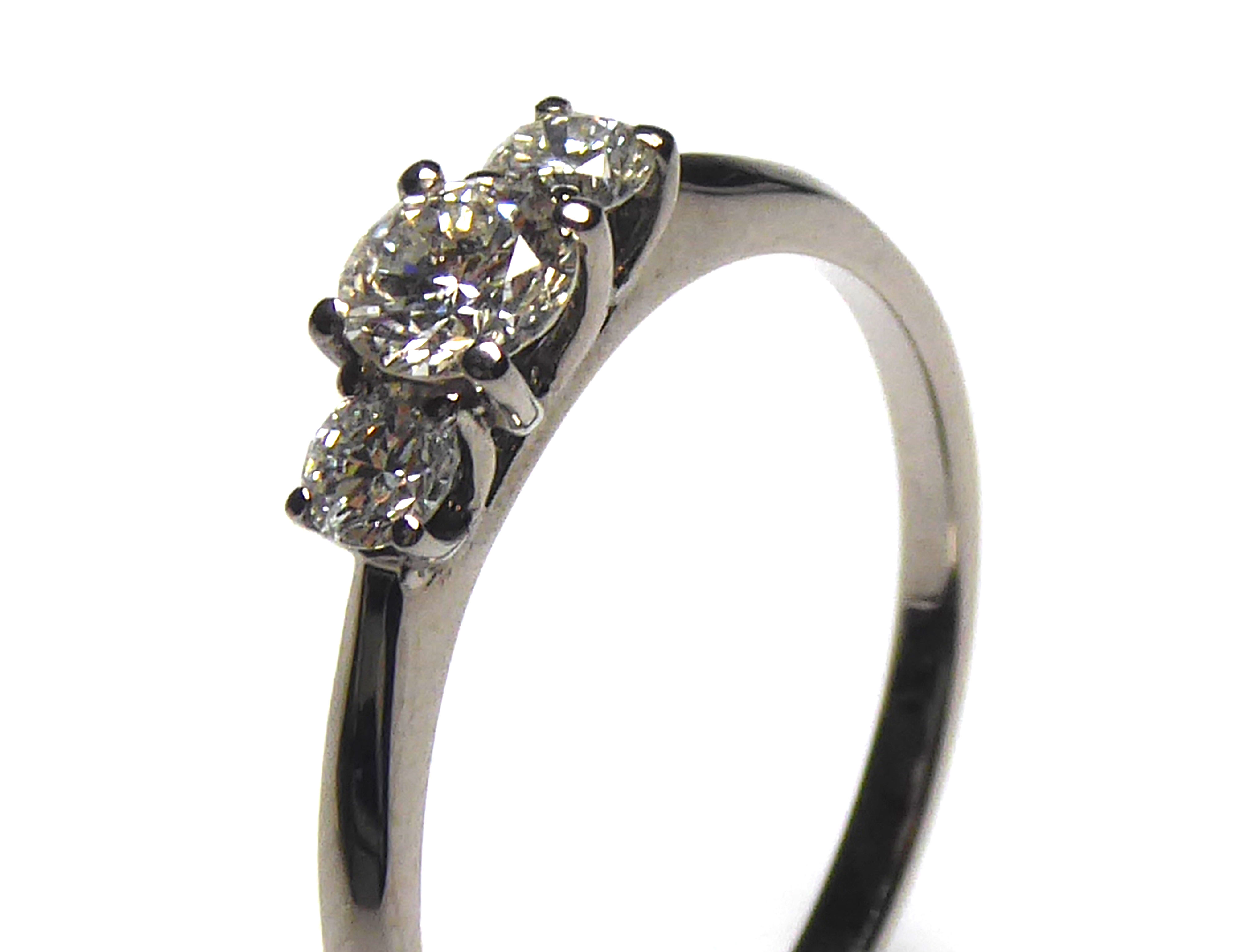 AN 18CT WHITE GOLD AND DIAMOND THREE STONE RING Having an arrangement of graduating round cut