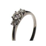 AN 18CT WHITE GOLD AND DIAMOND THREE STONE RING Having an arrangement of graduating round cut