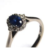 AN 18CT GOLD, SAPPHIRE AND ETHICAL DIAMOND RING Having an oval cut stone edged with diamonds (size
