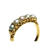 AN EARLY 20TH CENTURY 18CT GOLD AND PEARL FIVE STONE RING Having diamonds set to shoulders in an