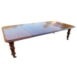 A VICTORIAN MAHOGANY EXTENDING DINING TABLE With three extra leaves, raised on turned faceted