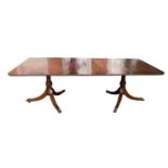 A REGENCY STYLE MAHOGANY EXTENDING DINING TABLE With one extra leaf, raised on turned columns with