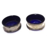 A PAIR OF EARLY 20TH CENTURY SILVER OVAL SALTS With blue glass liners. (approx 6cm)